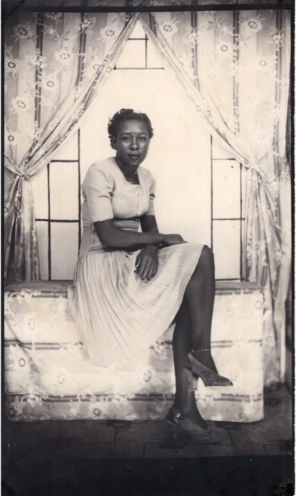 Woman sitting on floral bench by Unknown