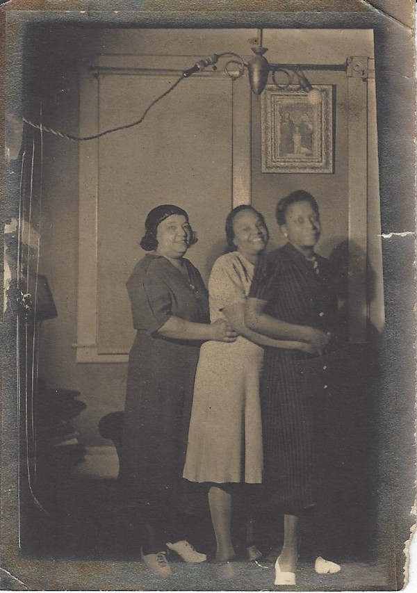 Three women embracing in apartment by Unknown
