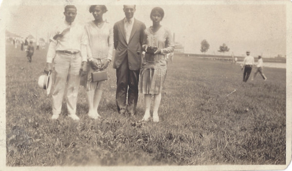 Foursome in a field; one woman holding a Brownie camera by Unknown