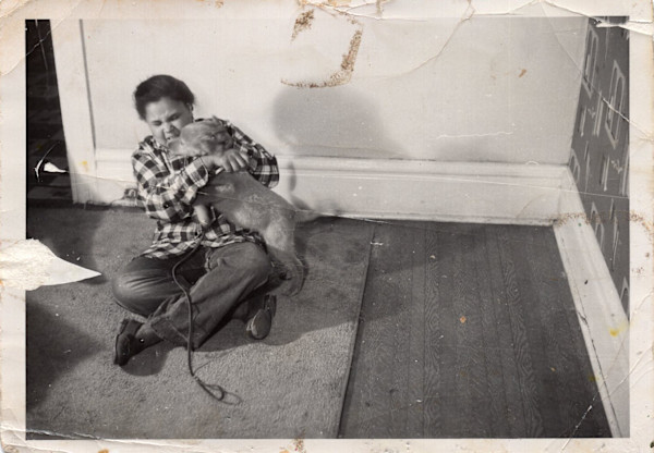 Girl wrestling with small dog by Unknown