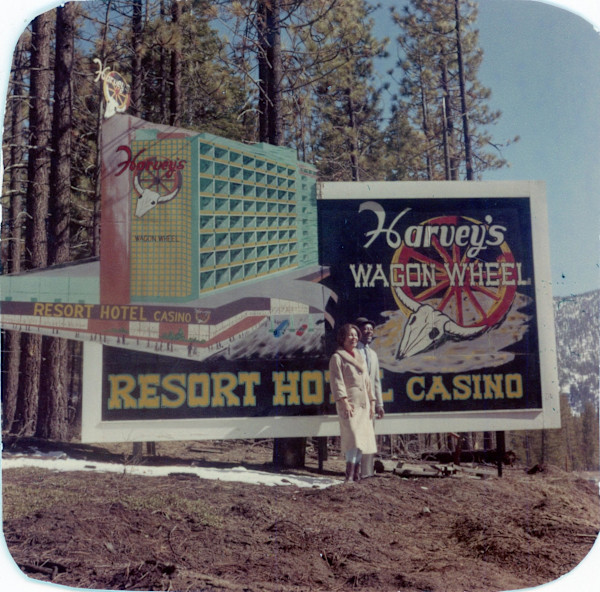 Martha & Louis standing by sign for Harvey’s Wagon Wheel Resort Hotel & Casino, Lake Tahoe by Unknown