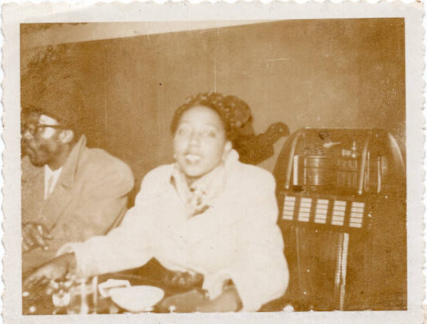 Man and woman at the bar with jukebox by Unknown