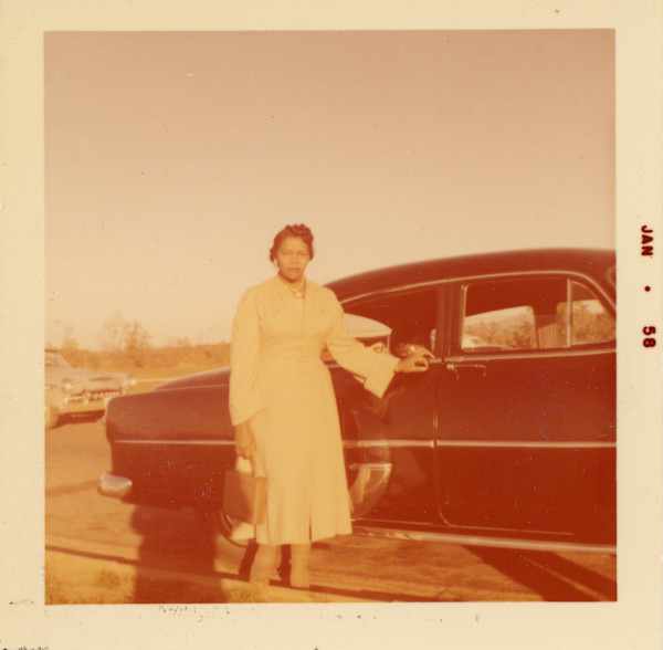 Lillie Estes Starks standing next to car by Unknown