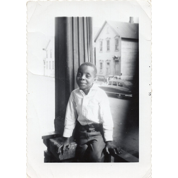 Boy sitting on porch rail (little Jimmie Baldwin) by Unknown