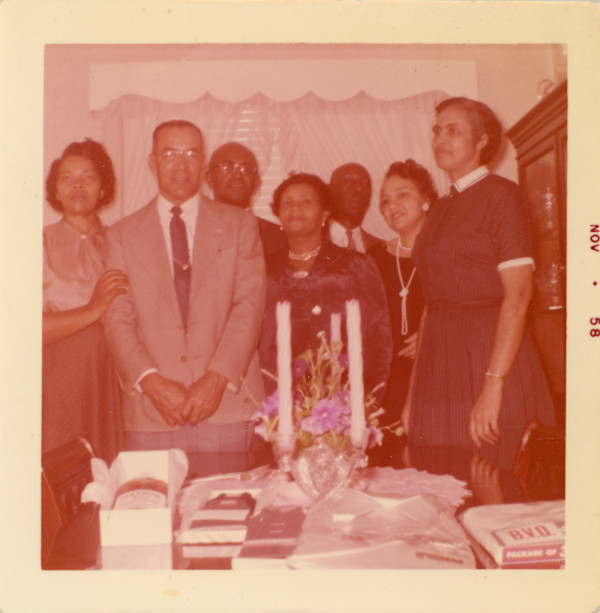 Group assembled around table by Unknown