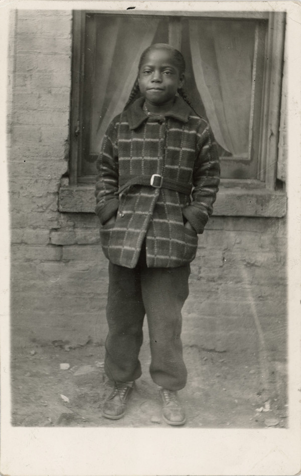 Young child standing next to window by Unknown