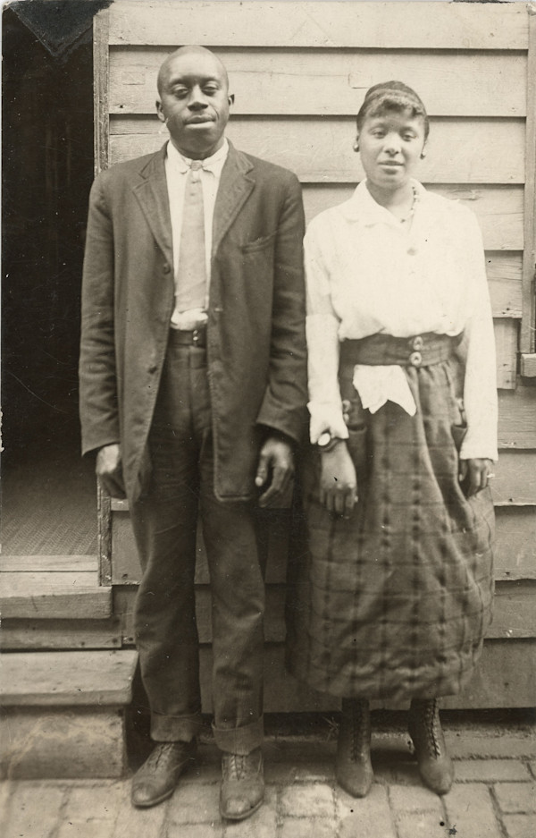 Couple standing outside home by Unknown