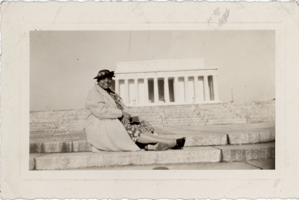 Woman posed with columned building in background by Unknown