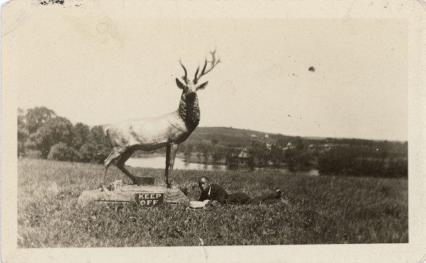 Keep Off (man lying under stag statue) by Unknown