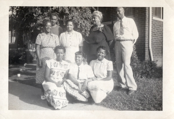 Group posed in front of house by Unknown