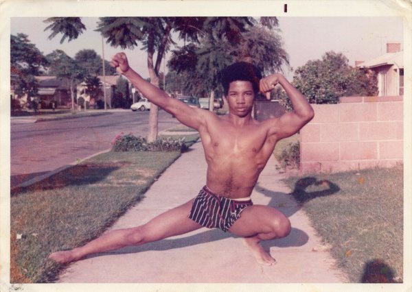 Man posing on sidewalk by Unknown