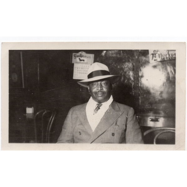 Well-Dressed Man in Hat in front of Frankenmuth calendar, Michigan by Unknown