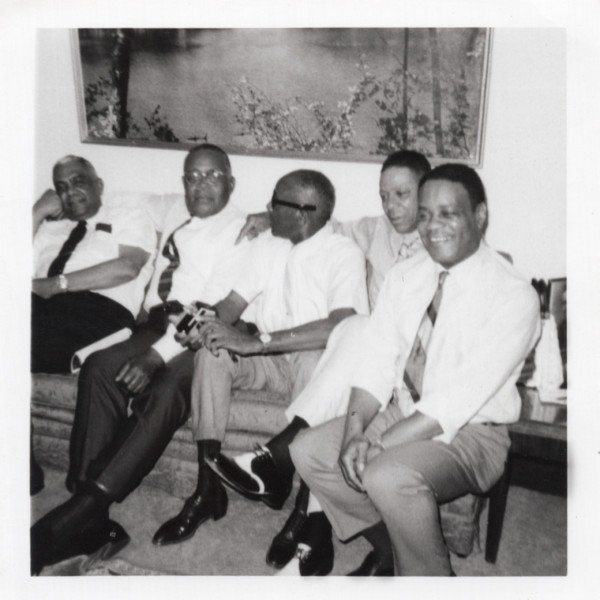 5 men, one w/ 110 flash camera by Unknown