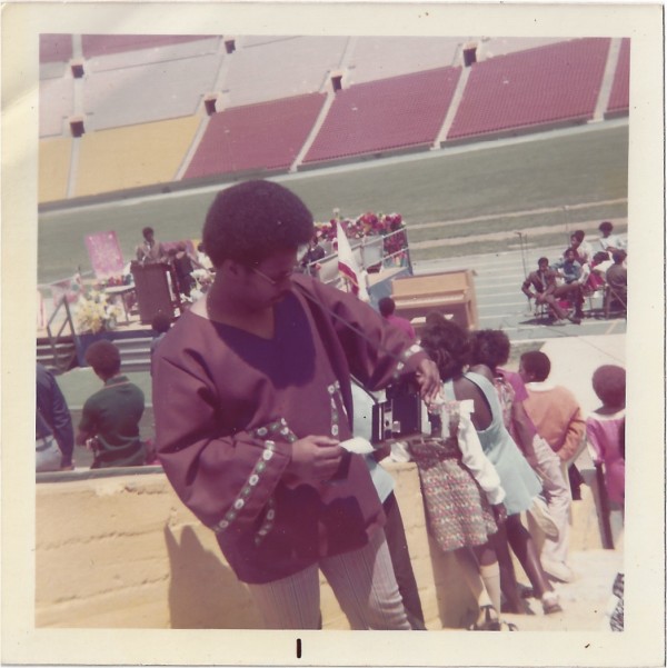 Man with Polaroid camera by Unknown