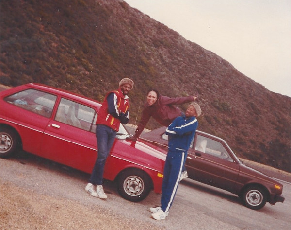 Trio posed with red car by Unknown