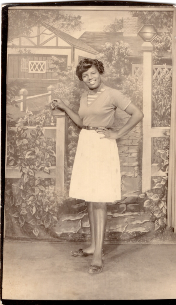 Woman standing at gate backdrop by Unknown