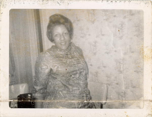 Woman in front of pale wallpaper by Unknown