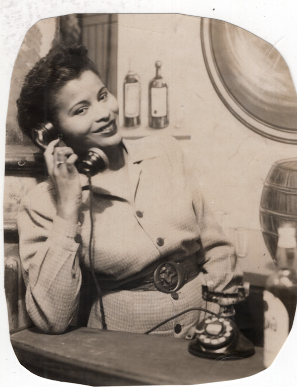 Arcade photo of woman in bar on telephone by Unknown
