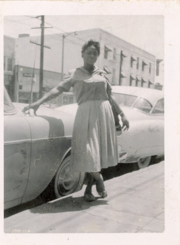 Woman standing next to car by Unknown