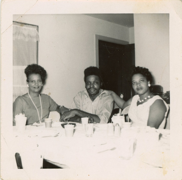 Trio at dining table by Unknown