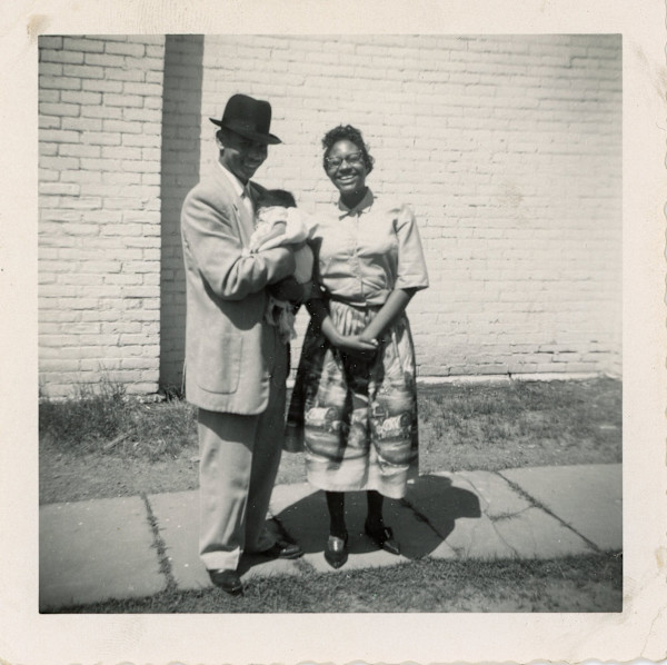 Woman with man holding a baby by Unknown