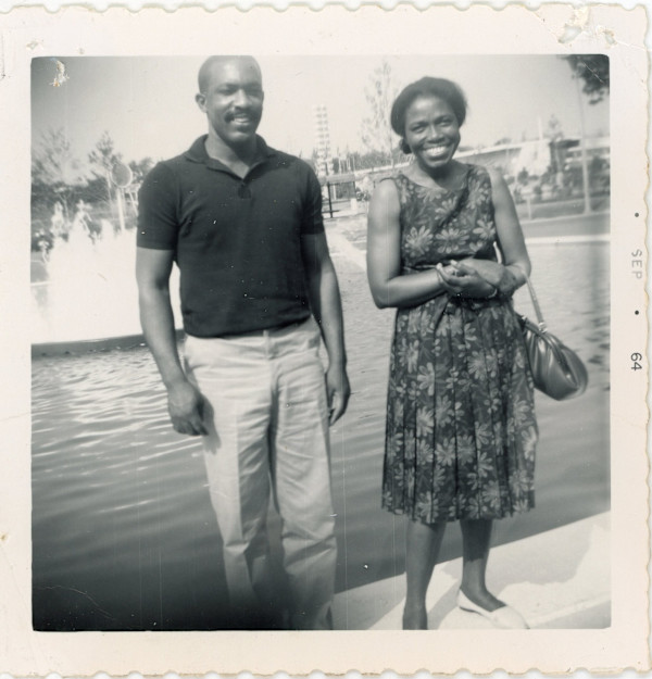 Woman & man standing by fountain by Unknown