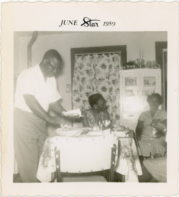 Folks eating in the kitchen by Unknown