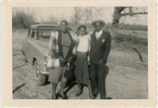 Trio posed in front of automobile by Unknown