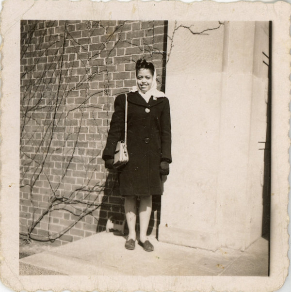 Young woman in dark coat and scarf by Unknown