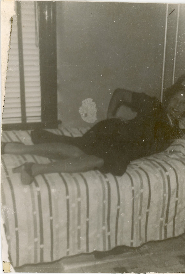 Woman reclining on bed by Unknown