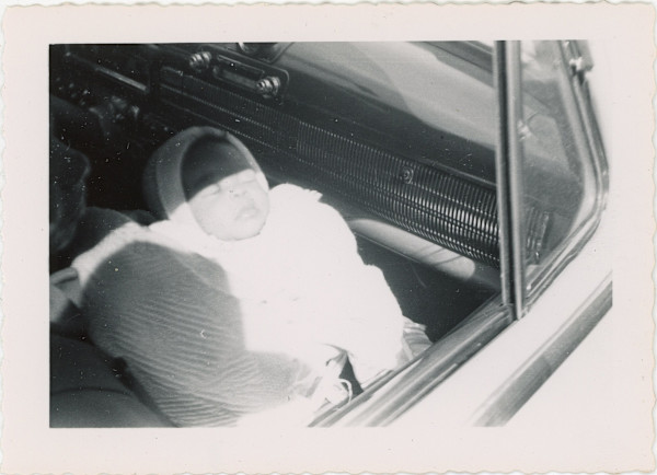 Infant held in automobile by Unknown