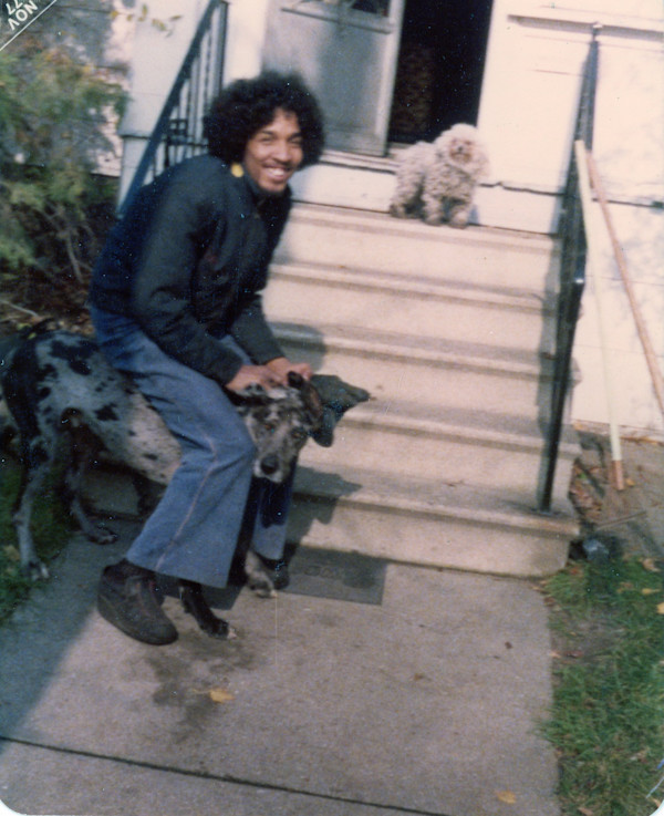 Man with black & grey dog and small white dog by Unknown