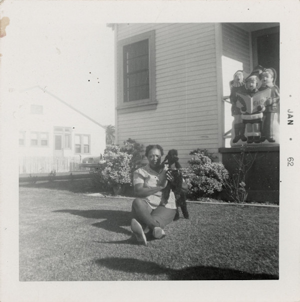 Woman on lawn with poodle by Unknown