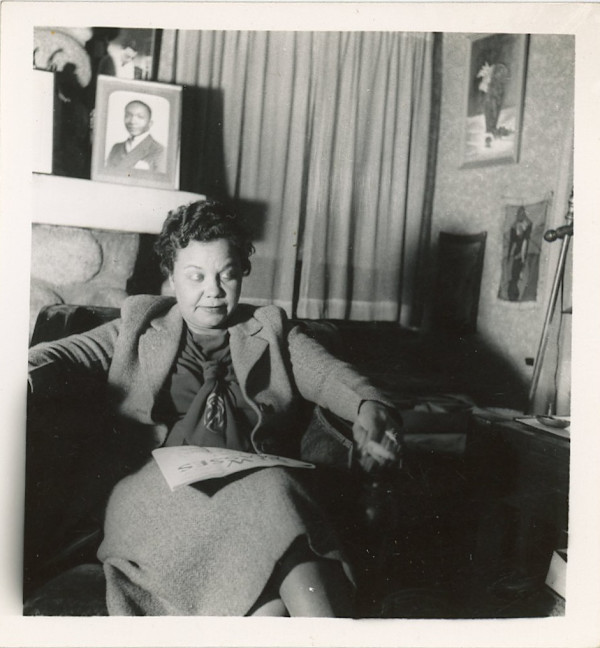 Seated woman with paper on lap by Unknown