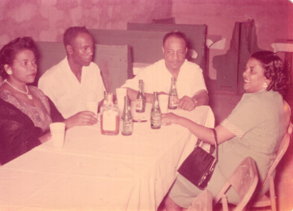 Foursome at restaurant table by Unknown