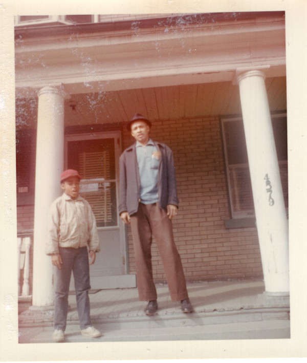 Man and boy standing between columns by Unknown