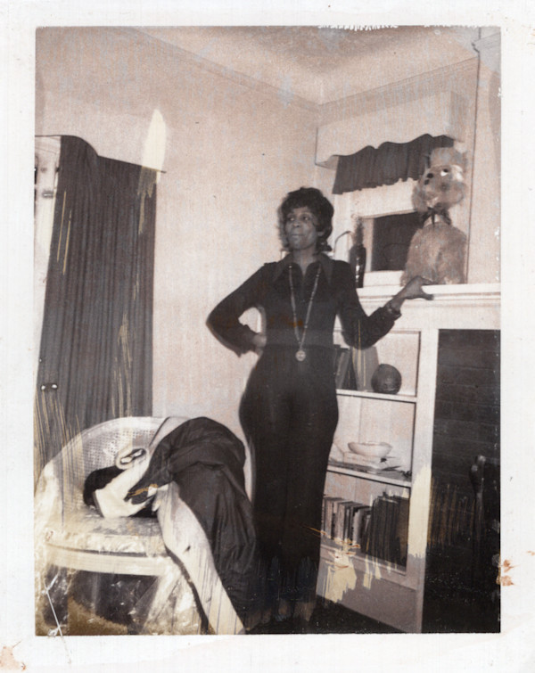 Woman standing next to stuffed animal on a shelf by Unknown
