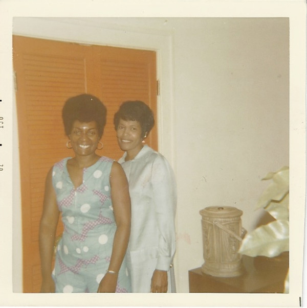 Woman in blue dress and friend by Unknown