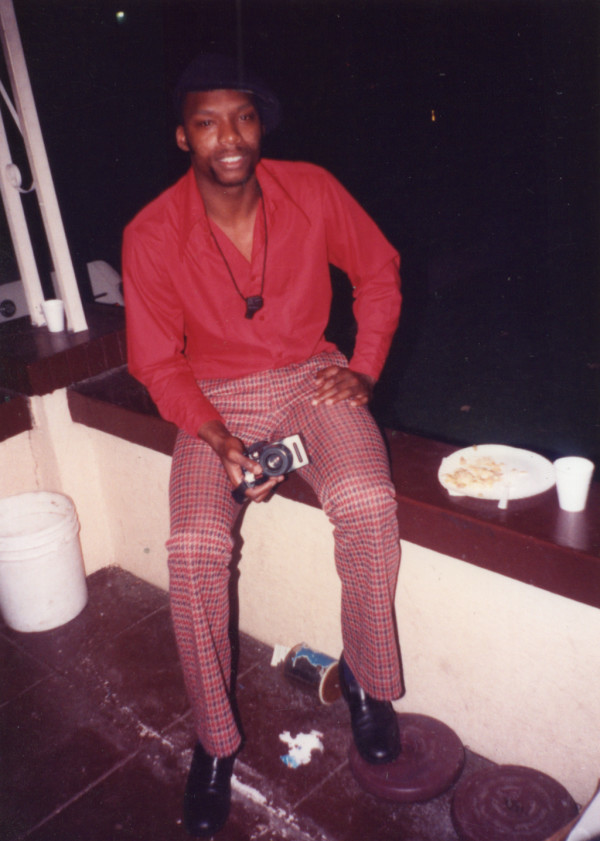 Seated man holding camera by Unknown