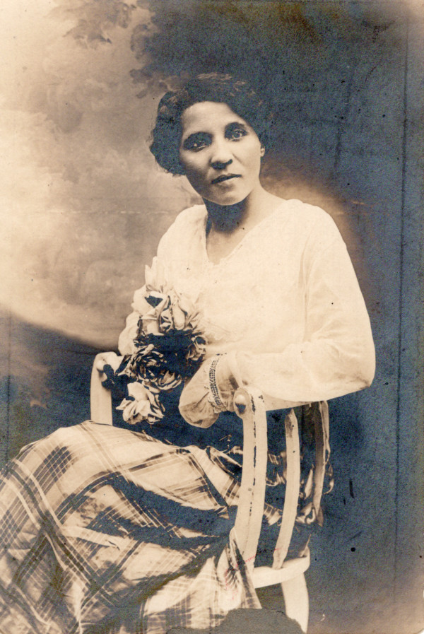 Seated woman holding flowers by Unknown