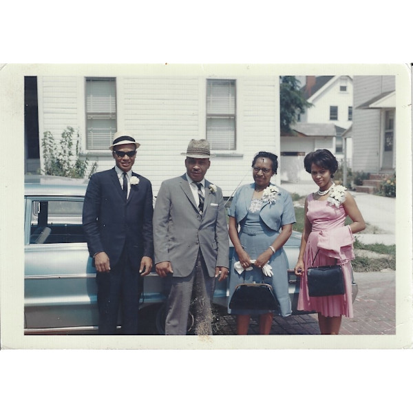 Foursome standing by car by Unknown