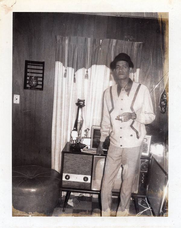 Man standing in front of television smoking by Unknown