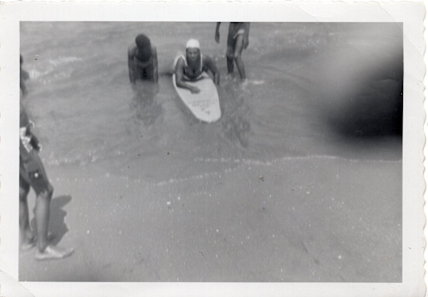 Woman on surfboard at shore by Unknown