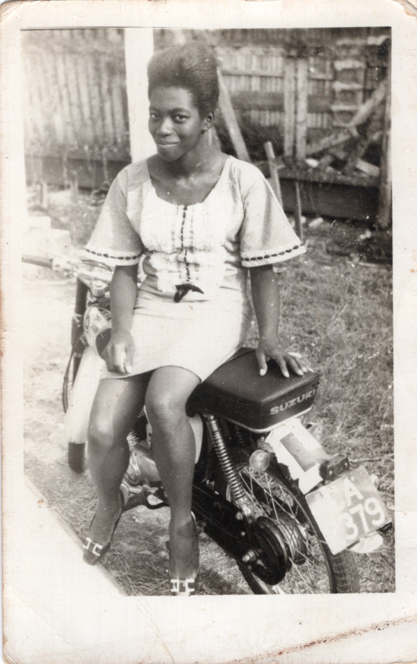 Woman sitting on Suzuki motorcycle by Unknown