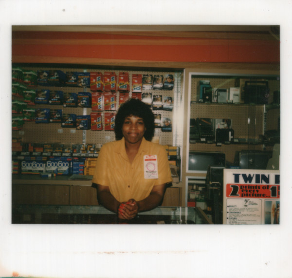 Woman behind Thrifty photo counter by Unknown