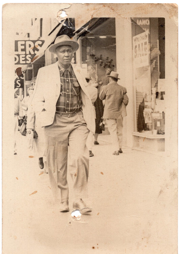Man walking down street by Unknown