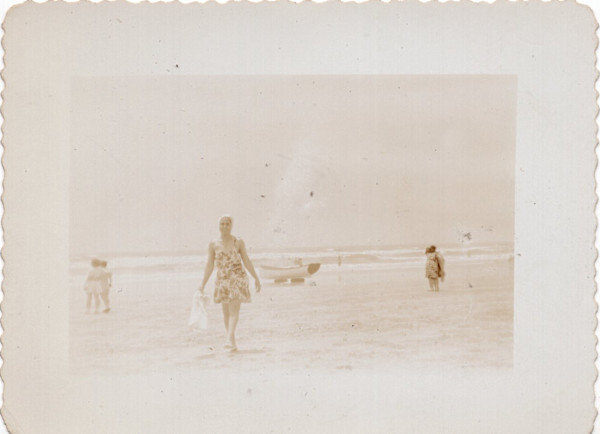 Woman walking along the beach by Unknown
