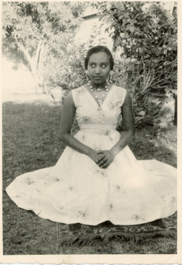 Woman sitting on the lawn glancing up and sideways by Unknown