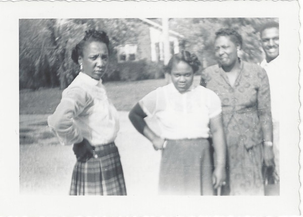 One man & three women, two with hands on hips by Unknown