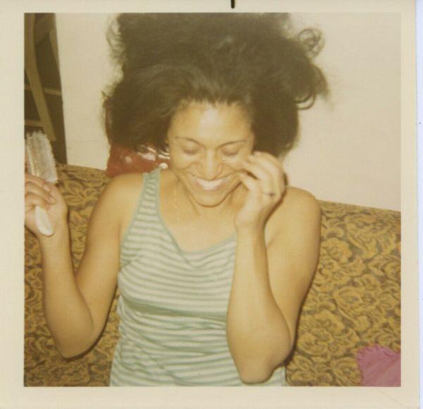 Woman brushing her hair by Unknown